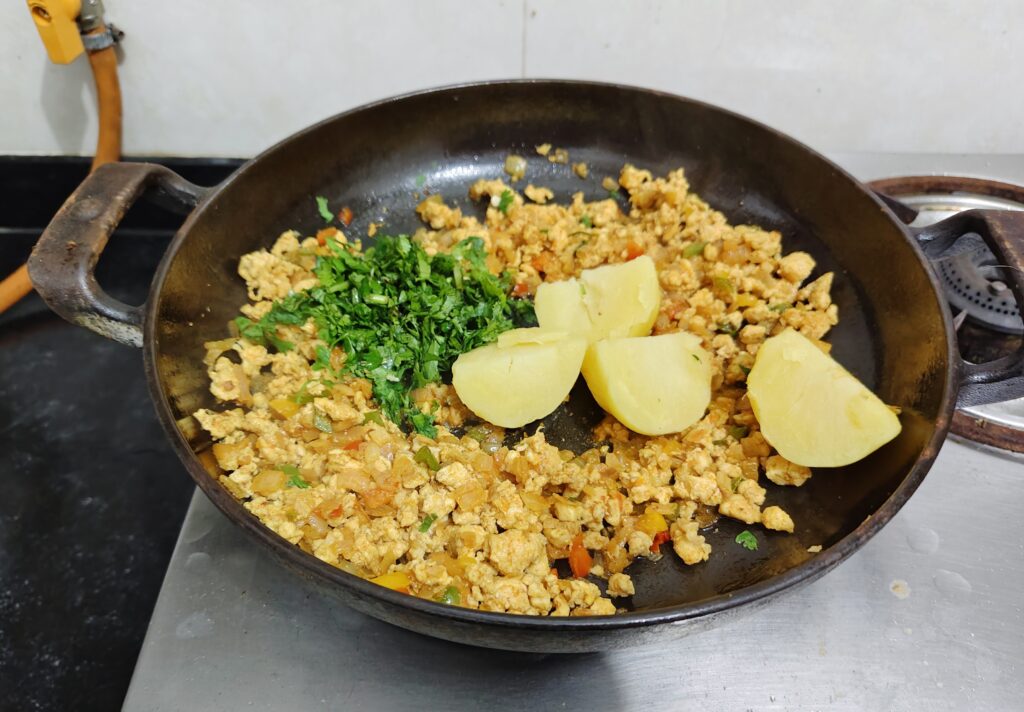 Add boiled potatoes and chopped coriander leaves