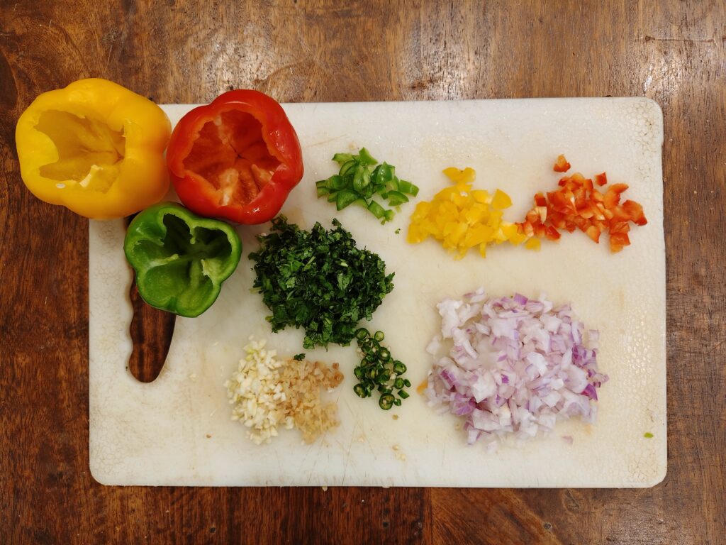 Finely Chopped Stuffing Ingredients and Decored Bell Peppers